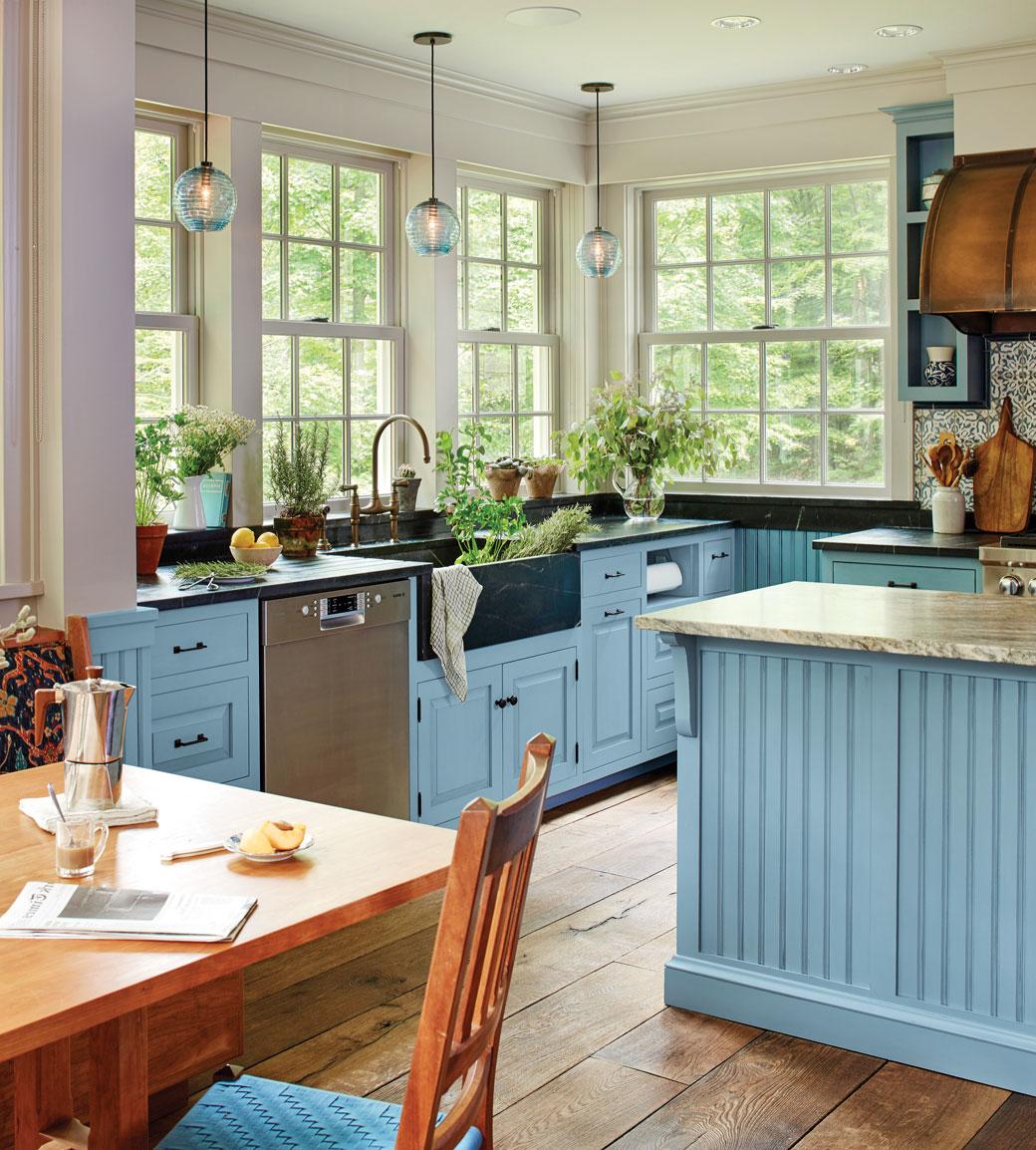 明亮的蓝色农舍厨房，带有围裙水槽和植物，由CrownPoint设计